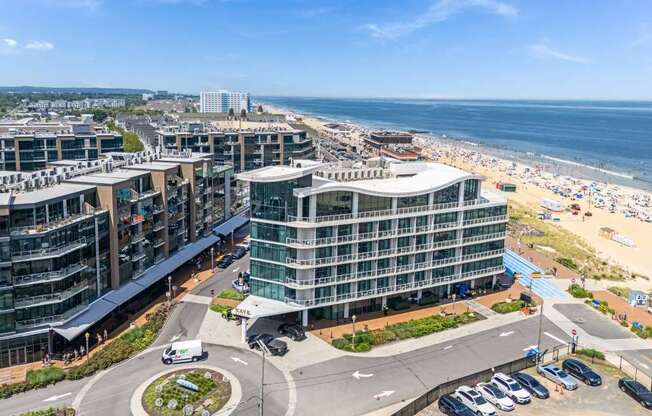 A view of a roundabout with a building in the background and a beach in the distance.