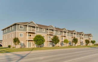 a street view of an apartment complex with a clear blue sky in the background