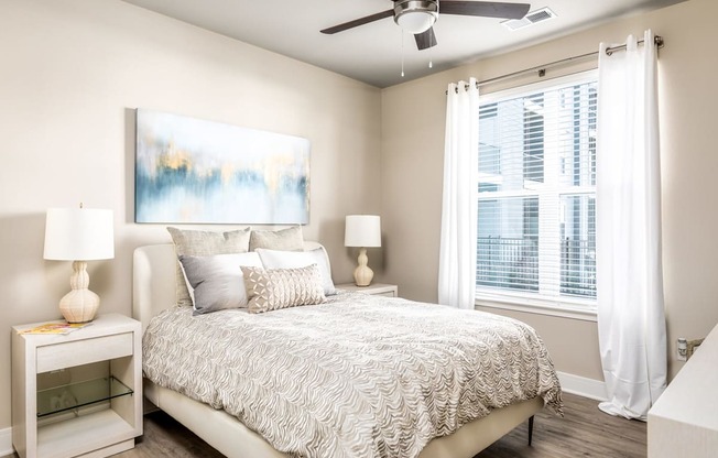 A bedroom with a large bed and a painting on the wall.