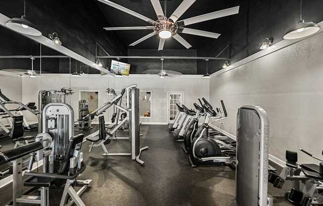 A gym with a variety of equipment including weights and cardio machines.