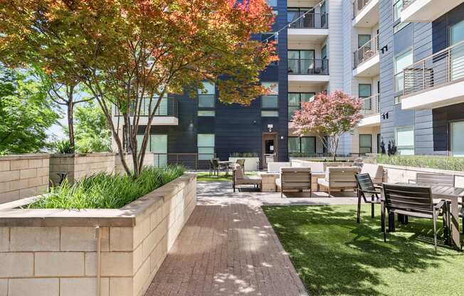 A modern apartment complex with a landscaped outdoor courtyard at Knox Heights Apartments in Dallas, TX