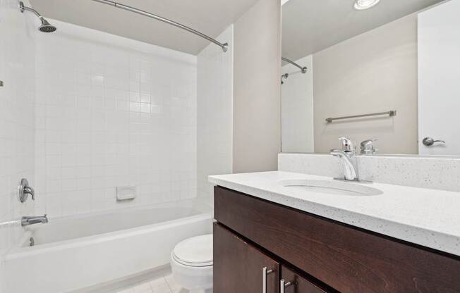 A white bathroom with a tub, toilet and sink.