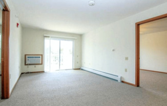 an empty living room with a door to a balcony