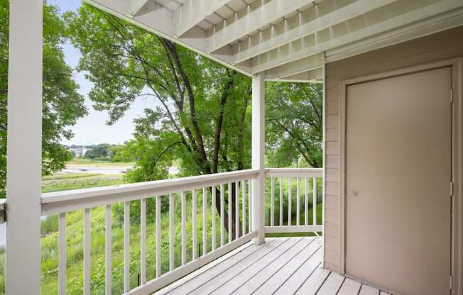 the view from the deck of a house with a door open to a porch