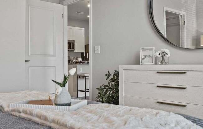 A bedroom with a bed, dresser, and mirror.