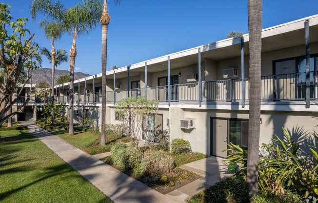 the courtyard of a condo building with palm trees at University Park, California