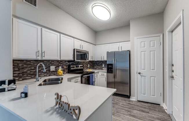 redesigned kitchen with white cabinets and stainless steel appliances at the preserve at great neck apartments