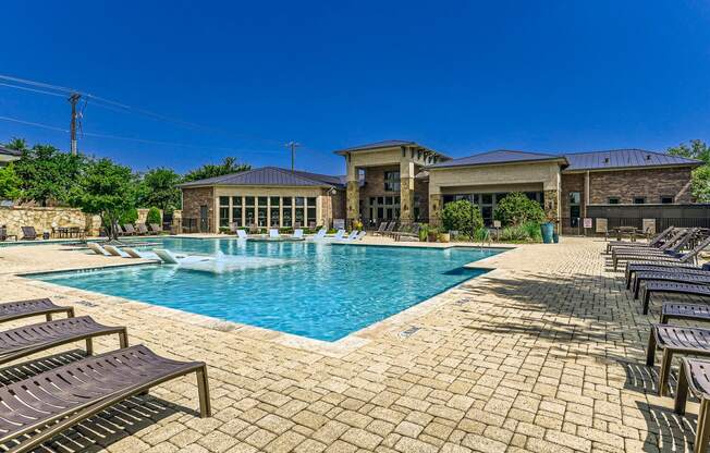a swimming pool with chairs and a building in the background at Discovery at Craig Ranch, McKinney, TX, 75070