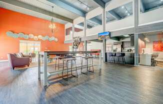 A modern open space with a bar and seating area.