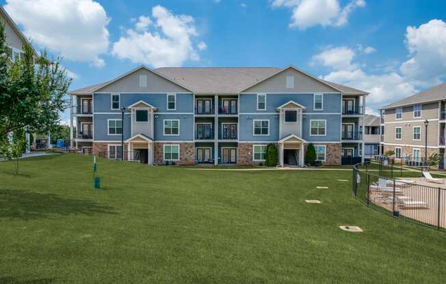 an apartment building with a yard and a batting cage