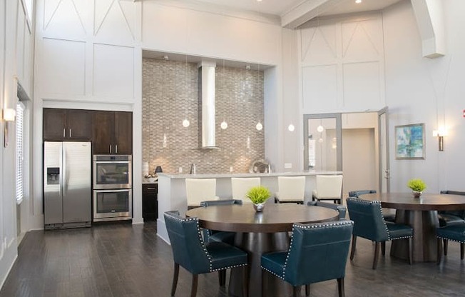 a dining room and kitchen with blue chairs and a table at GrandView Flats and Townhomes, Granger, IN