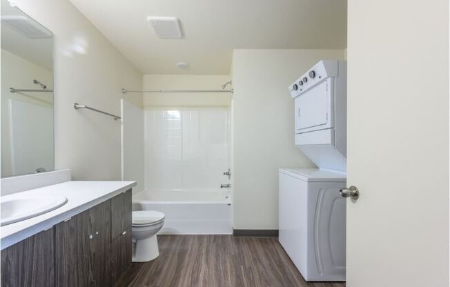 a bathroom with a toilet sink and a washer and dryer