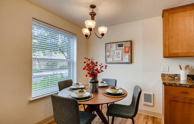 Apartments near Happy Valley for Rent - Sunnyside Village - Dining Room off of Kitchen with Large Window, White Walls, and Wood Flooring