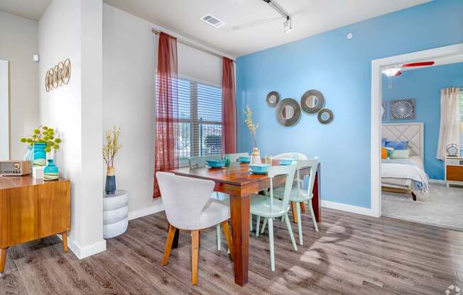 A dining room with a wooden table and chairs.