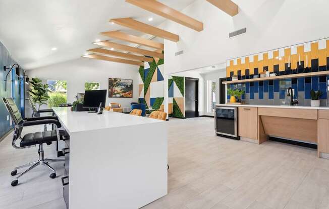 A modern office with a white reception desk and a black office chair.