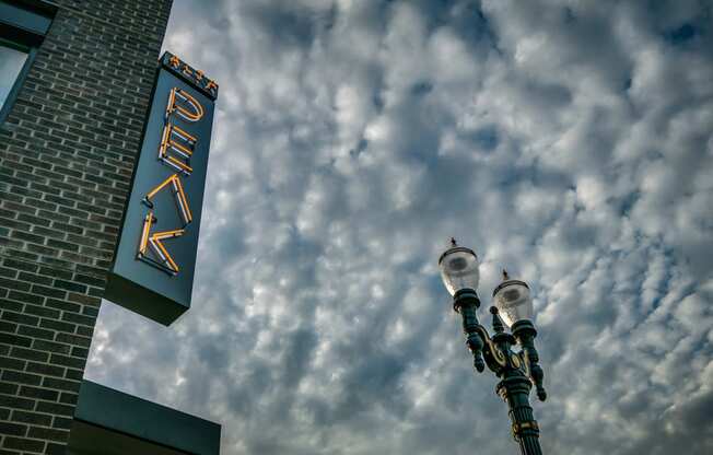 a sign on the side of a building with a cloudy sky