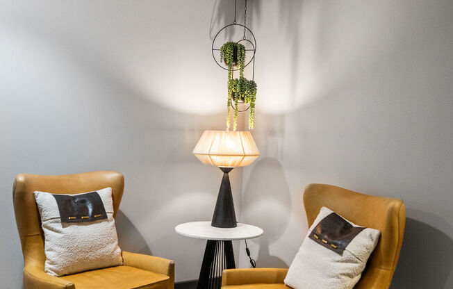 Two yellow chairs with cushions are placed in a room with a hanging plant and a table at Madison Prickett Preserve, Pennsylvania