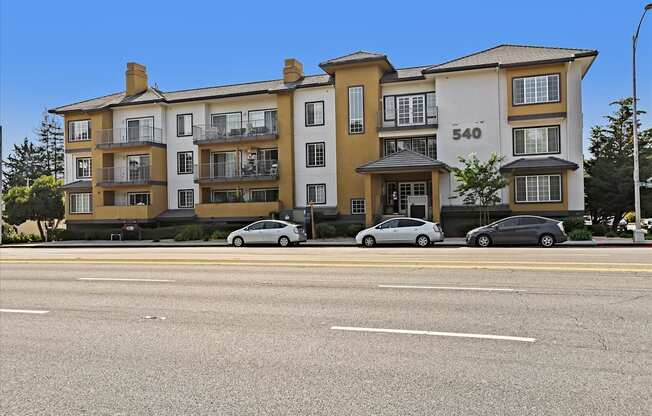 Apartment building number 540 with cars parked in front.