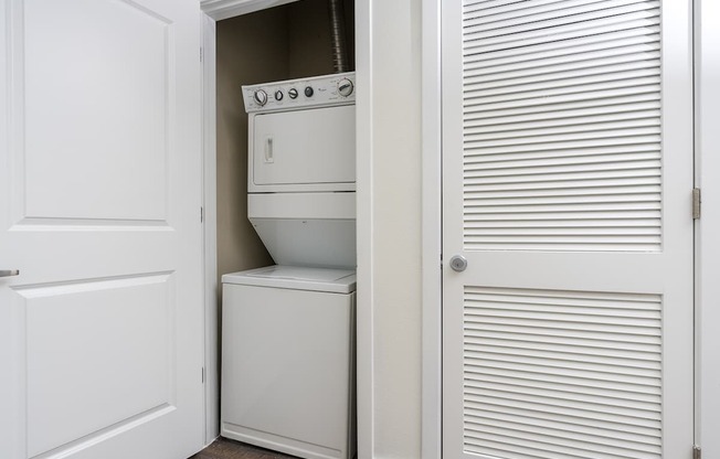 A white oven and dishwasher are installed in a kitchen cabinet.
