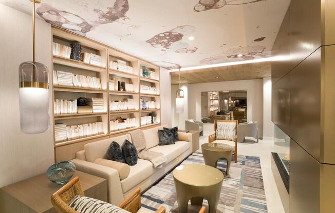 A refined resident lounge with built-in shelving, layered textures, and a fireplace backdrop for relaxed moments at Modera Liberty Row.