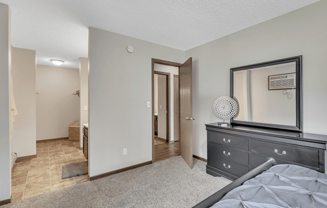 a bedroom with a dresser and mirror