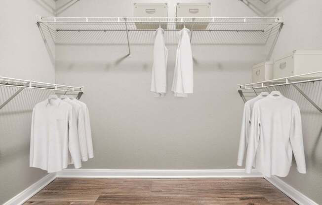 A white shirt is hanging on a clothes rack in a room.