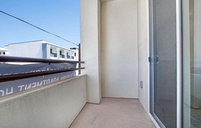 a balcony with a door and a blue sky in the background