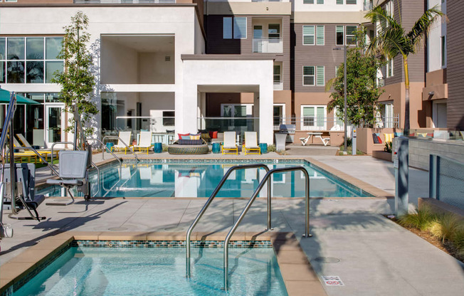 A swimming pool in front of a building with a white entrance.