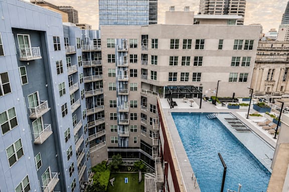 A large swimming pool is surrounded by apartment buildings.