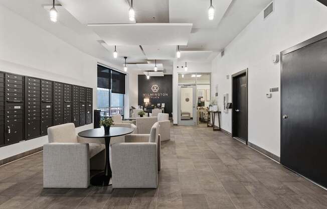 A black and white image of a modern office lobby with a table and chairs.