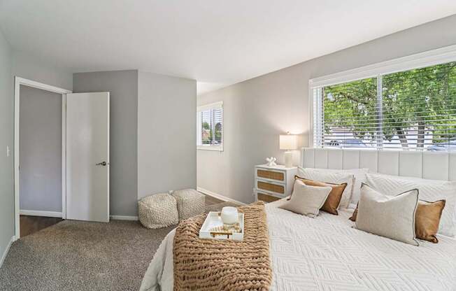 Bright bedroom with plush bedding and natural light at Ashford at Geneva – pet-friendly apartments in Geneva, Illinois