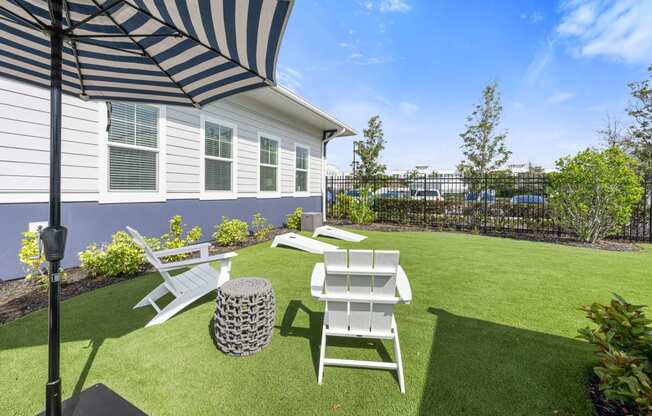 communal lawn area with a patio with chairs and an umbrella