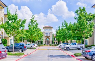 Spacious parking lot at Mission at La Villita Apartments in Irving, TX offers 1, 2 & 3 bedroom apartment homes with appliances.