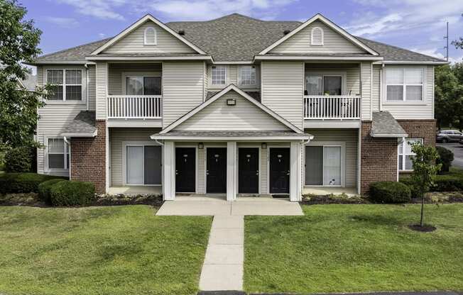 the front of a house with a sidewalk in front of it