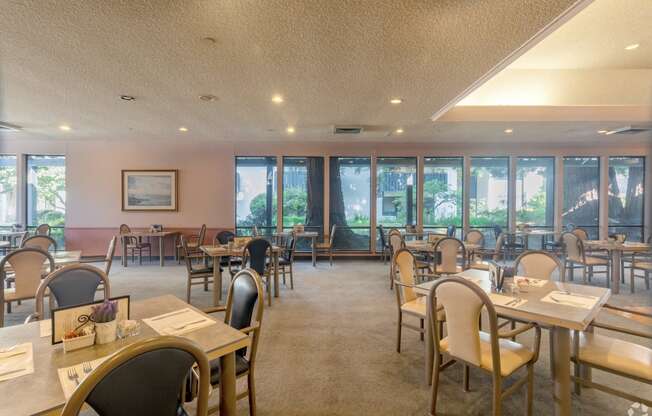 a dining room with tables and chairs and windows in a restaurant