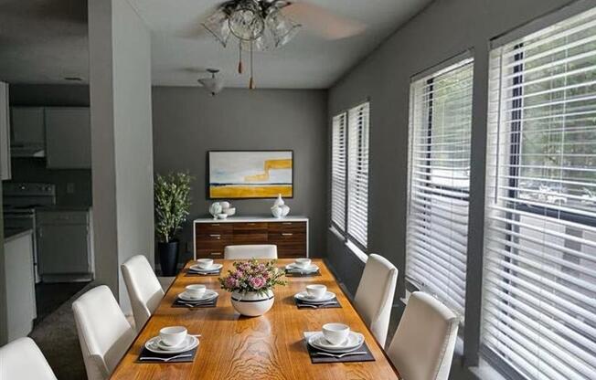 A dining room with a wooden table set for six.