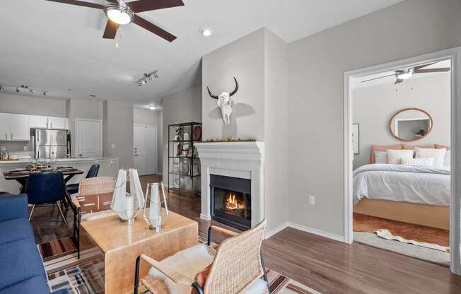 A living room with a fireplace and a bedroom in the background.