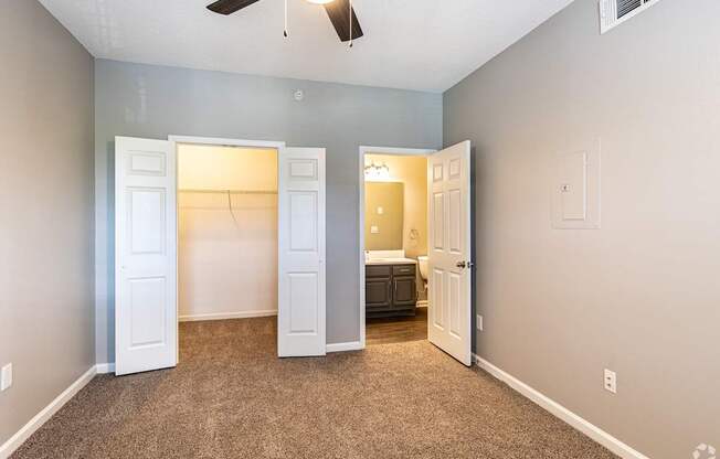 A room with a ceiling fan and a carpeted floor.