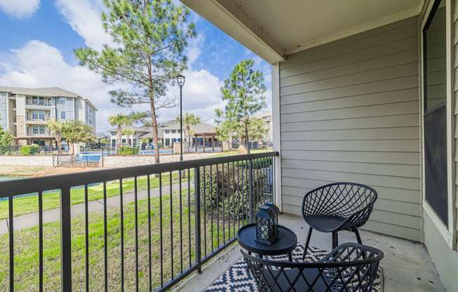 a patio with two chairs and a table on a balcony