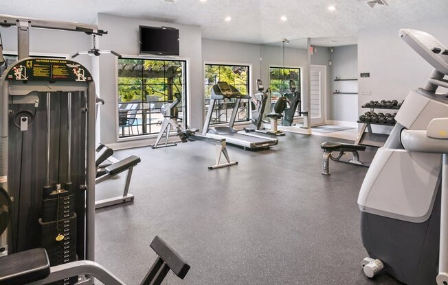 A gym with a variety of equipment including treadmills, weights, and exercise machines at Ridge Crossings Apartments, Hoover, AL