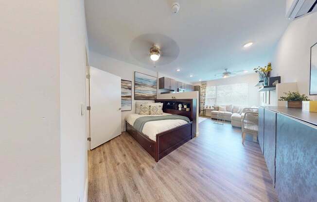 A bedroom with a bed, a chair, and a mirror.