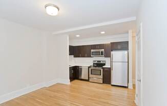 A kitchen with a white fridge and stove top oven.