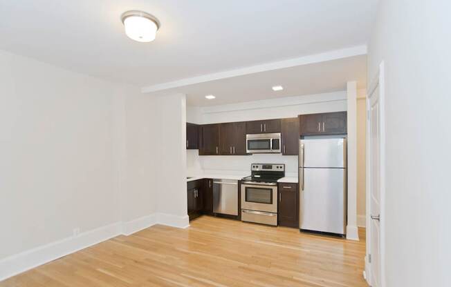 A kitchen with a white fridge and stove top oven.