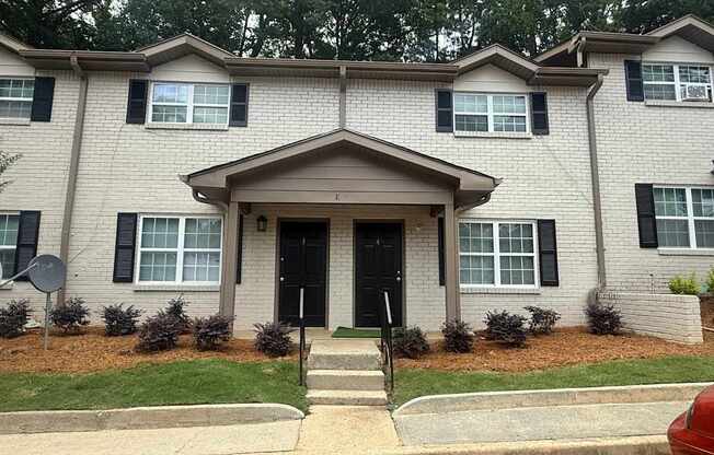 A two-story house with a black front door and windows with black frames.