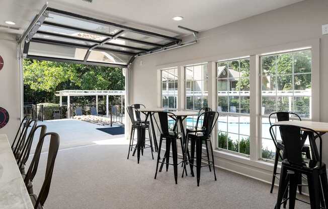 A room with a table and chairs and a pool table.