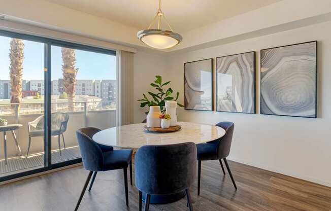 a dining room with a large window and a table with chairs at The Rays at Vegas Towers Apartments, Las Vegas, NV