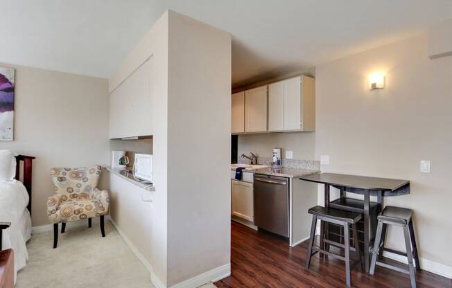 Dining area with wood style floors and kitchen on the left