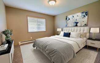 a bedroom with a bed and a painting on the wall. Fargo, ND Urban Plains Apartments