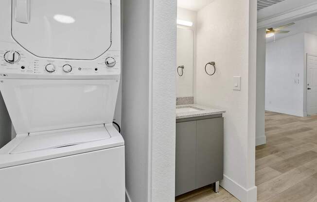 A white bathroom with a toilet, sink, and mirror.