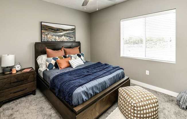 A bedroom with a large bed and a painting on the wall.